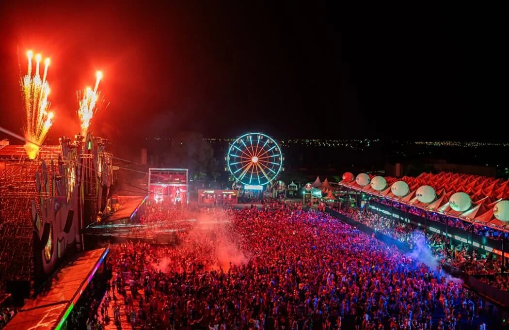 Multidão, roda-gigante e fogos de artifício durante o Oba Festival à noite
