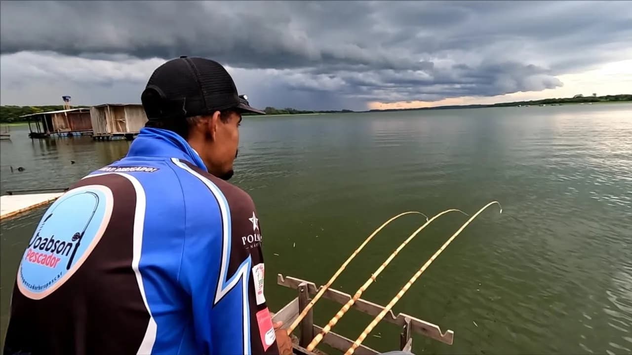 Joabson, do canal Joabson Pescador, pescando em um lago com céu nublado ao fundo